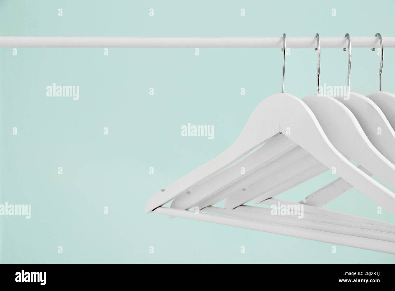 Rack with clothes hangers on light background Stock Photo - Alamy