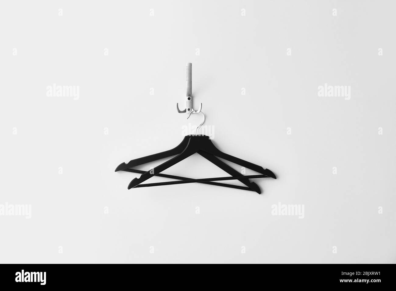 Clothes hangers on white wall Stock Photo Alamy