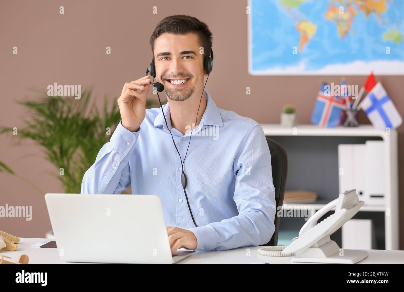 Male travel agent working in office Stock Photo