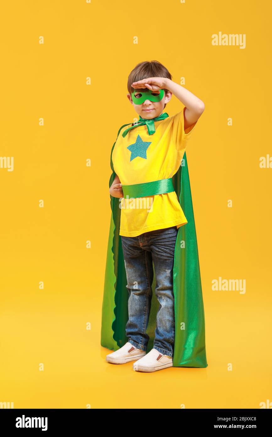 Cute little boy dressed as superhero on color background Stock Photo