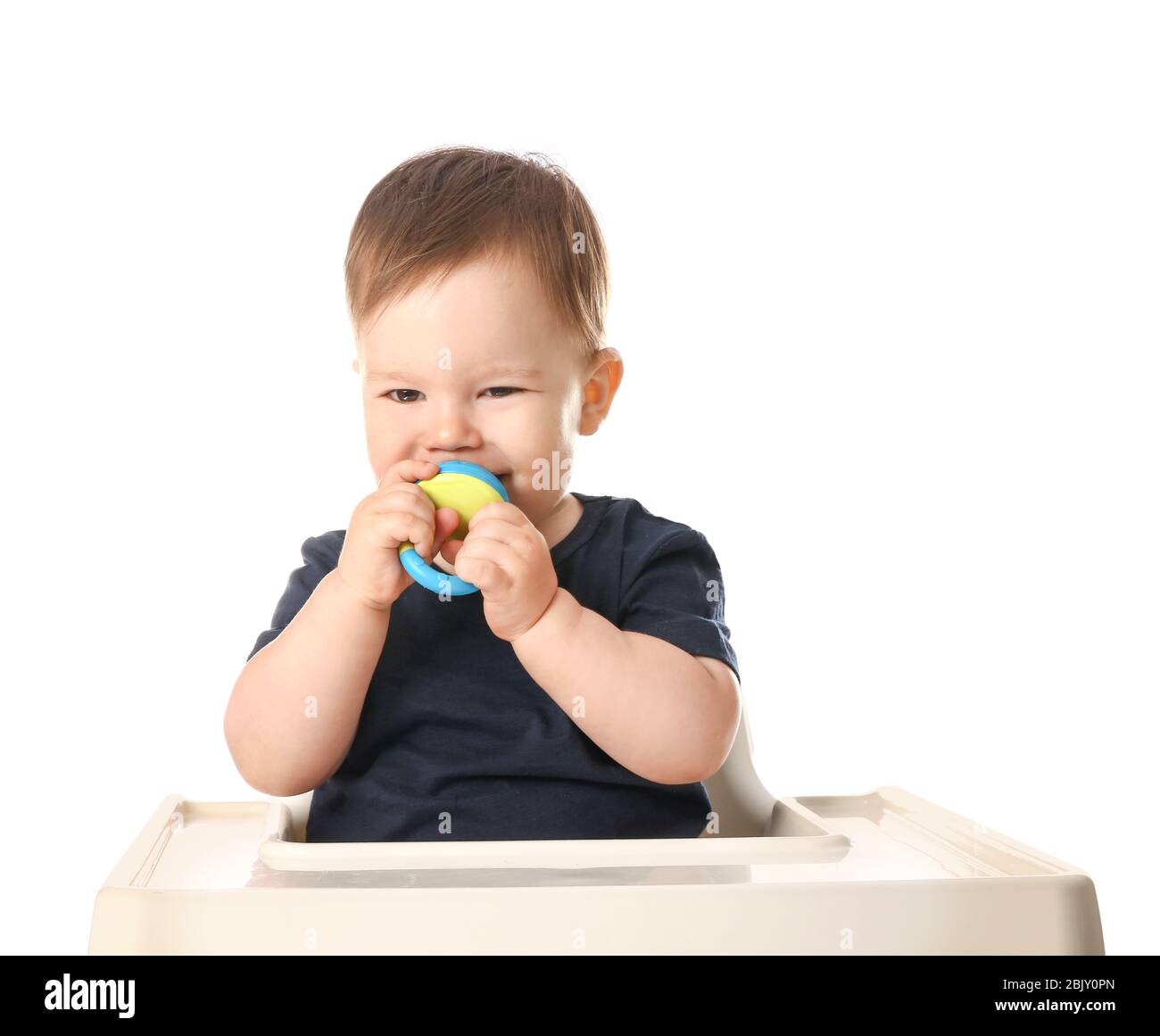 Cute little boy with nibbler sitting in high chair against white