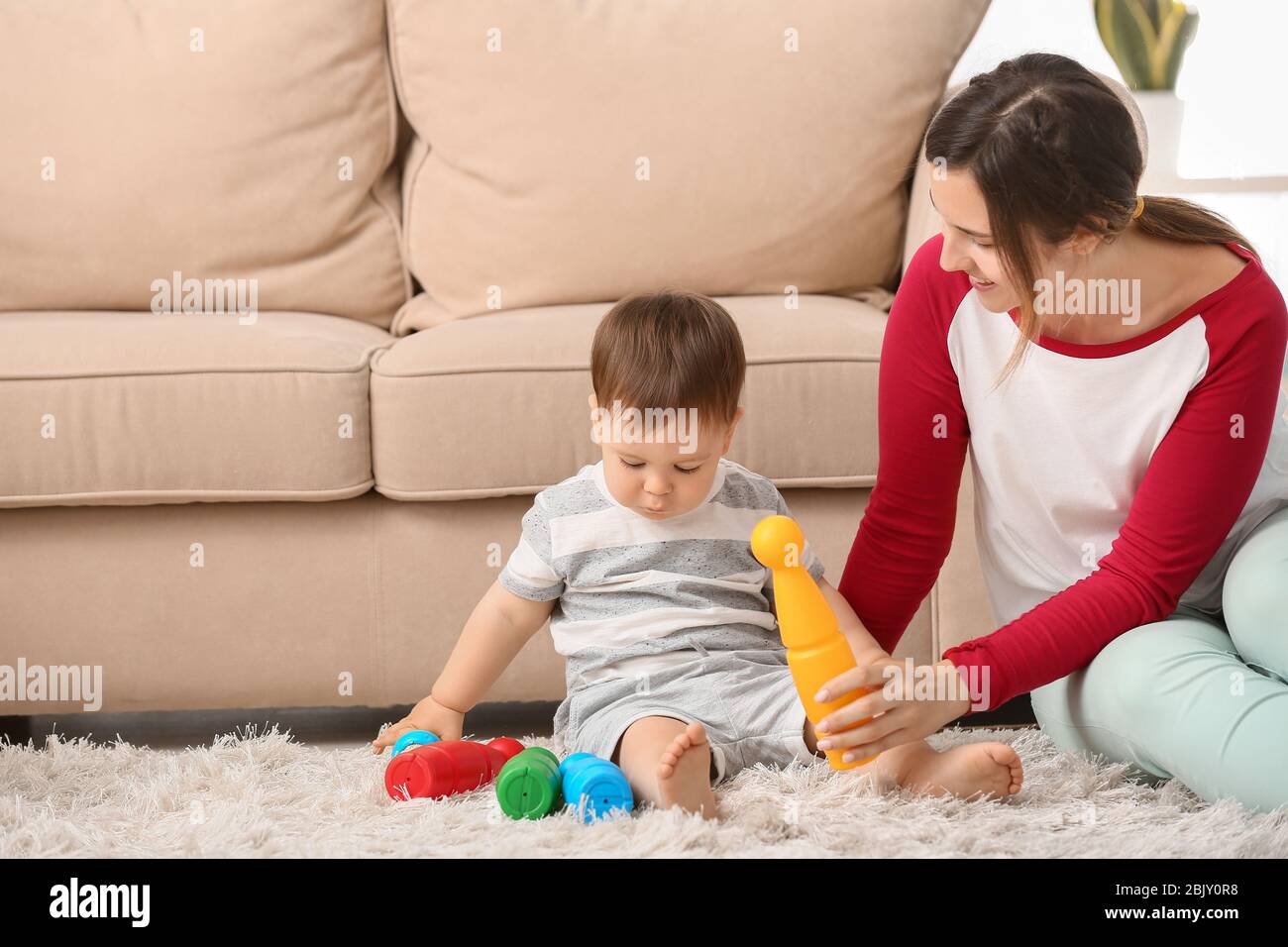 Mother and cute baby boy playing with toys at home Stock Photo - Alamy