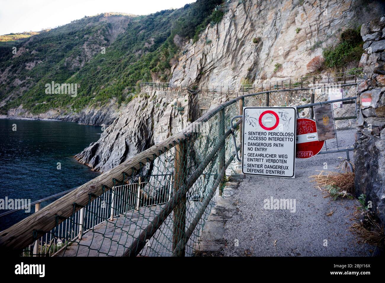 Famous trail blocked with closed signs alerting to the danger from rock slides at the beginning of the coastal trek connecting the five villages from Stock Photo