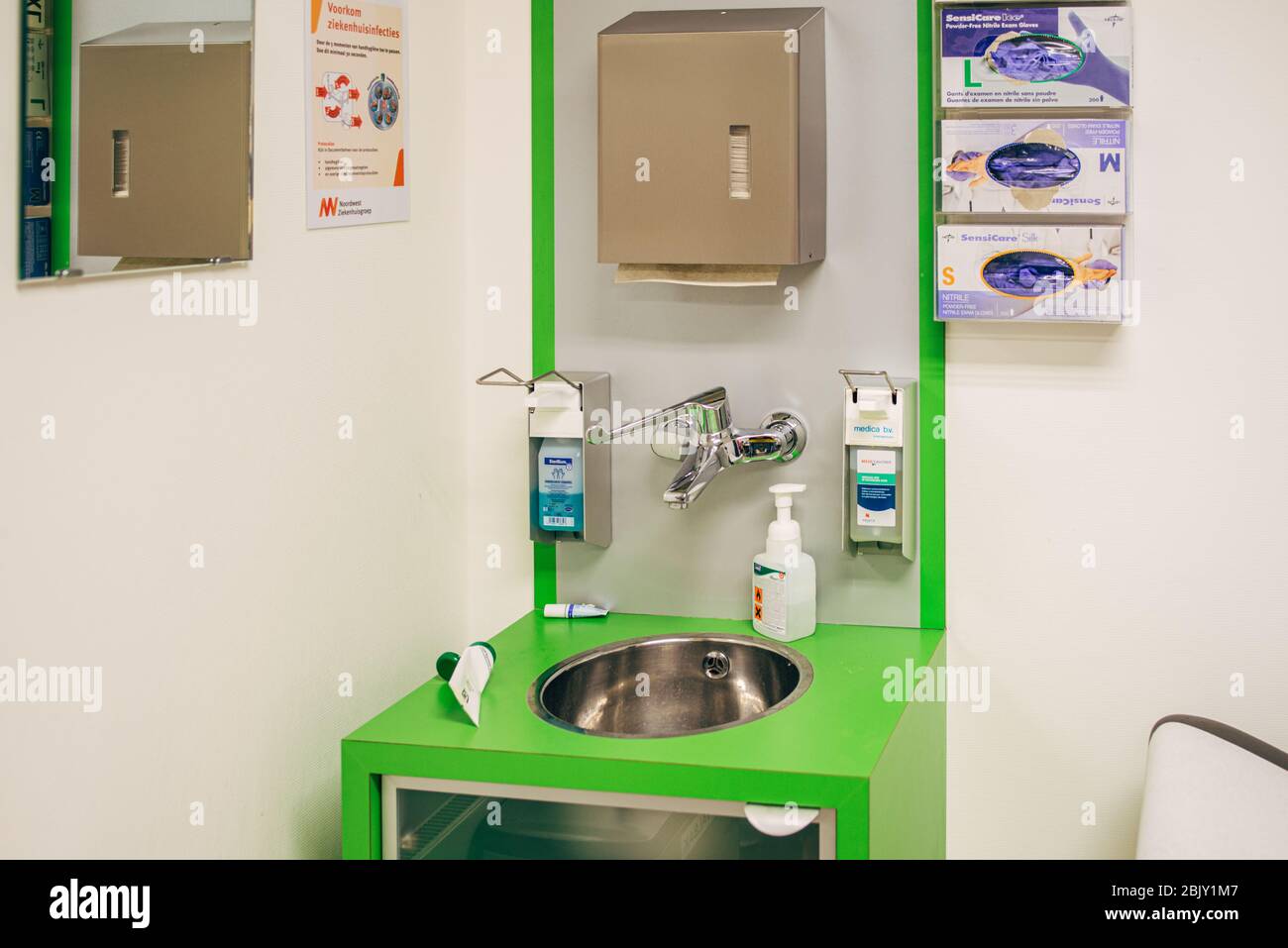 Disposable gloves mounted on wall in emergency department in hospital in Netherlands. Protective Medical Gloves and Hand Sanitizer Stock Photo
