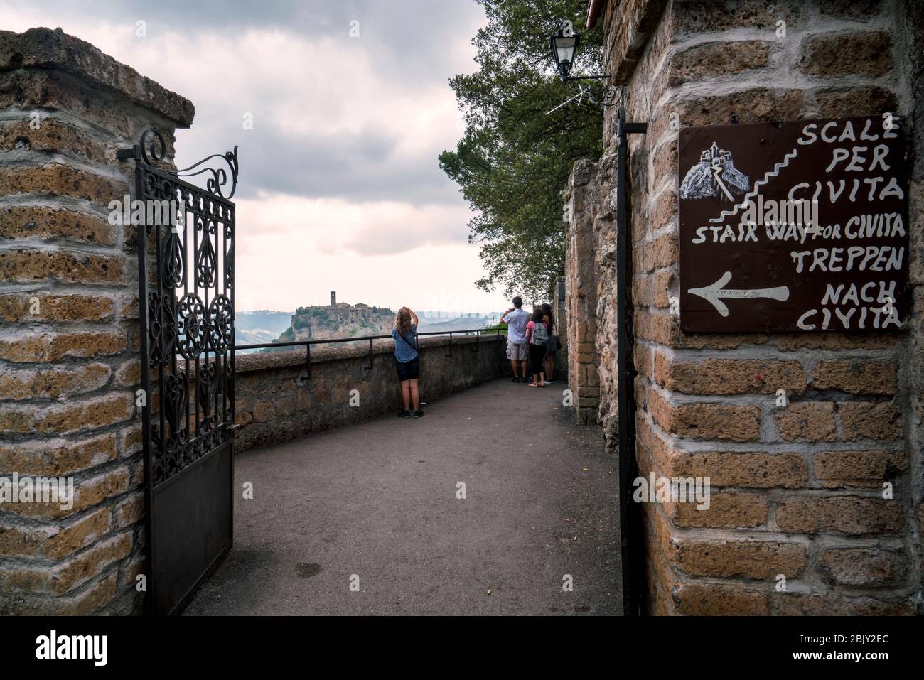Entrance to the long pedestrian footbridge leading to Cività di Bagnoregio, Civita Bagno, an ancient Etruscan hilltop village perched atop volcanic tu Stock Photo