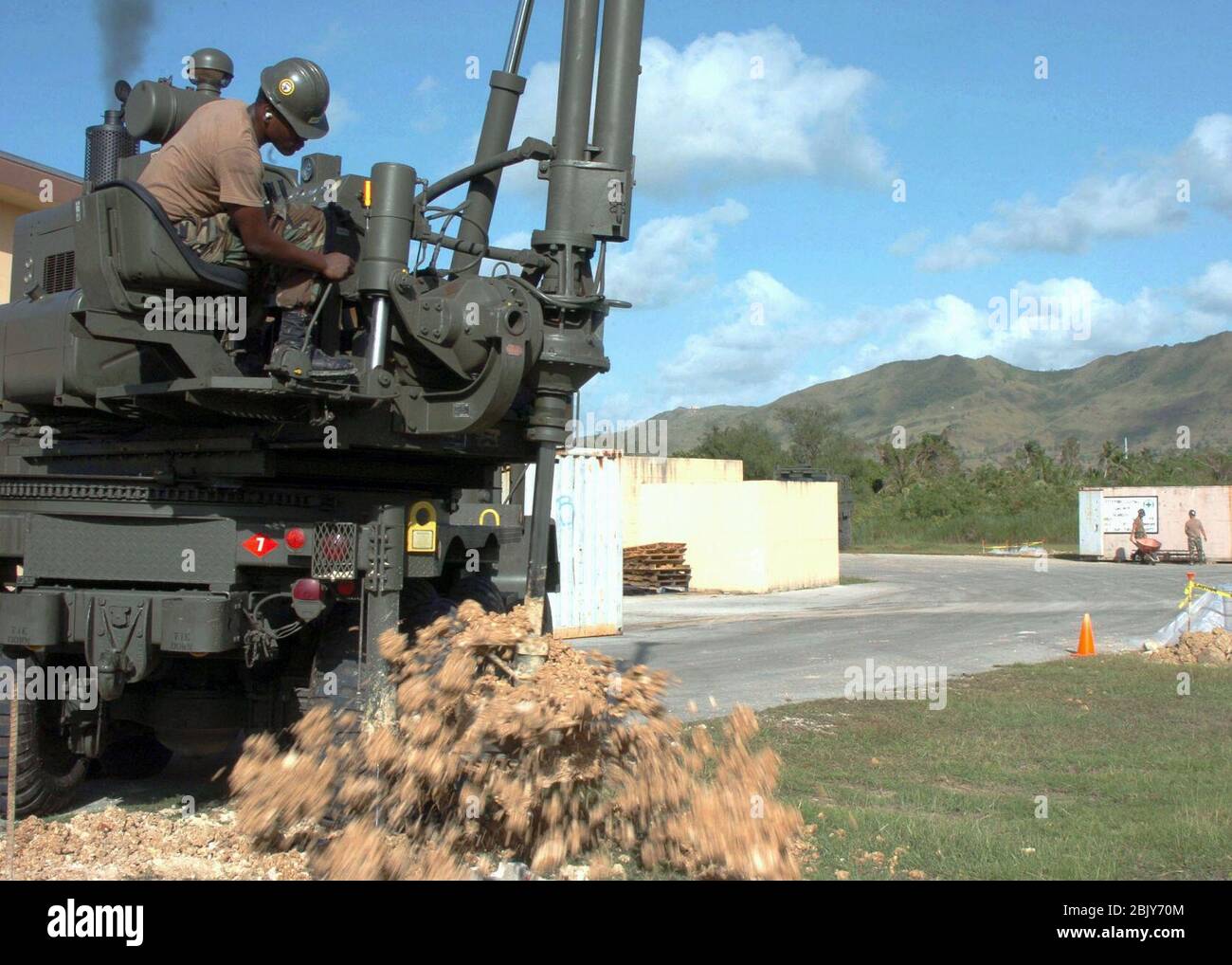 Constructionman assigned to Naval Mobile Construction Battalion Seven (NMCB-7), spins dirt off the blade of an auger, after drilling a hole for a lamp pole on Camp Covington, Guam. Stock Photo