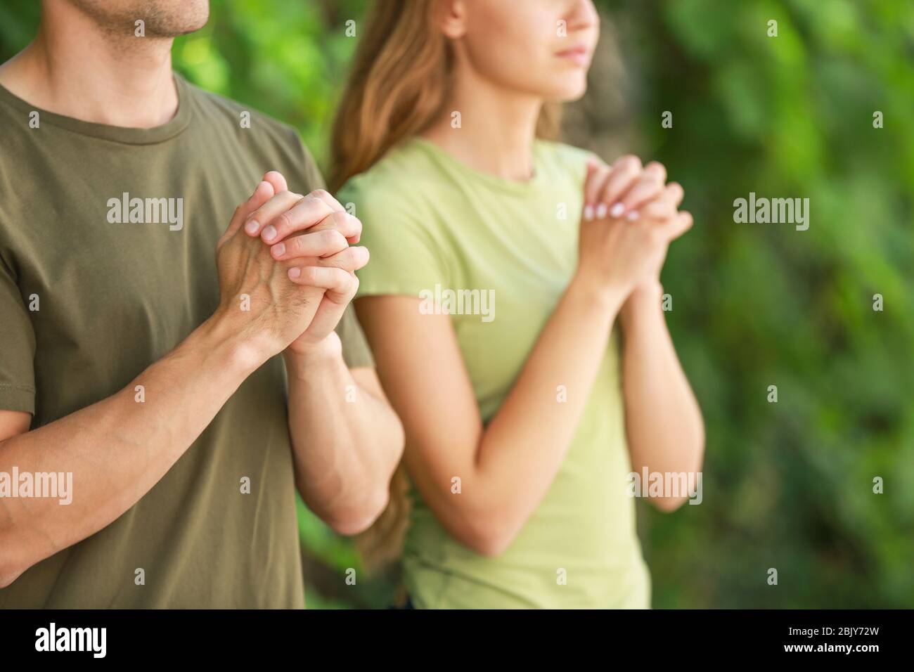 Religious couple praying to God outdoors Stock Photo Alamy