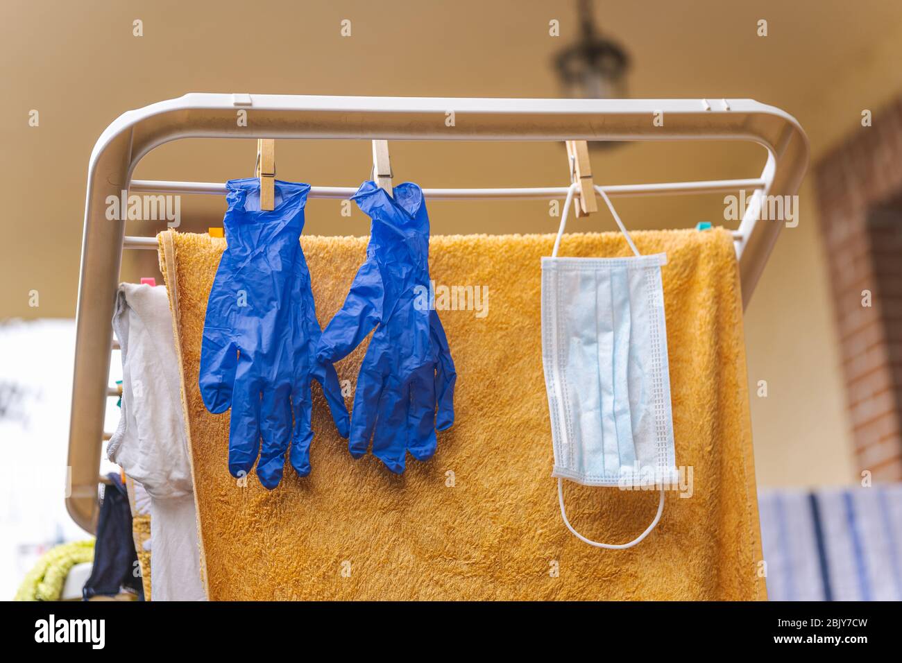 Medical gloves and surgical mask hanging on a clothesline for reuse