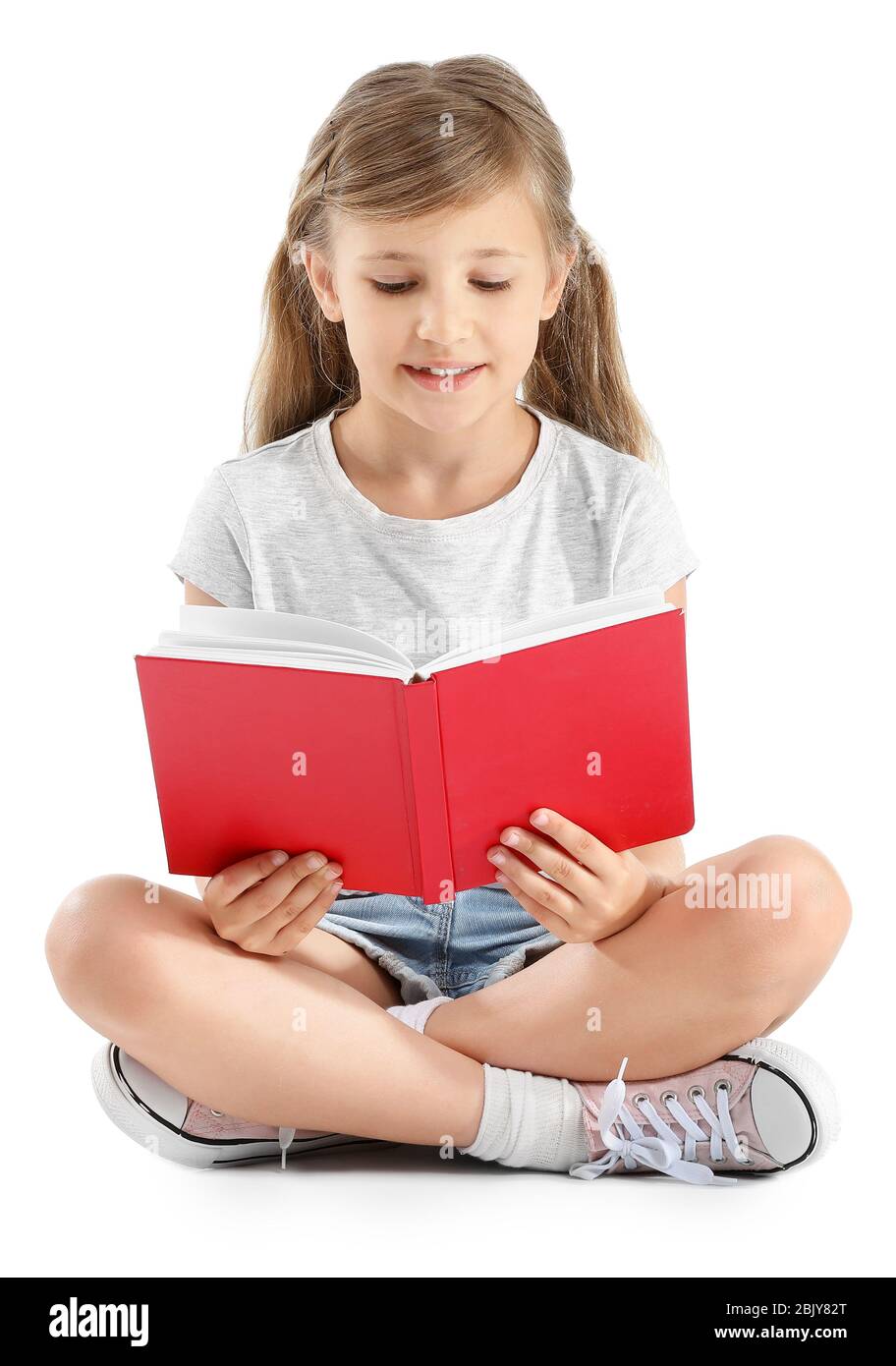 Little girl with book on white background Stock Photo - Alamy