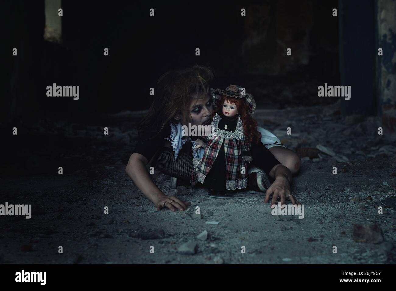 scary girl with a doll in an abandoned house Stock Photo