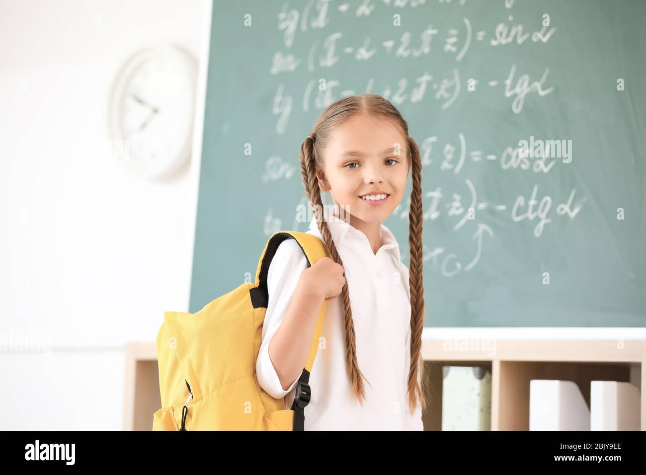 Cute little schoolgirl in classroom Stock Photo - Alamy
