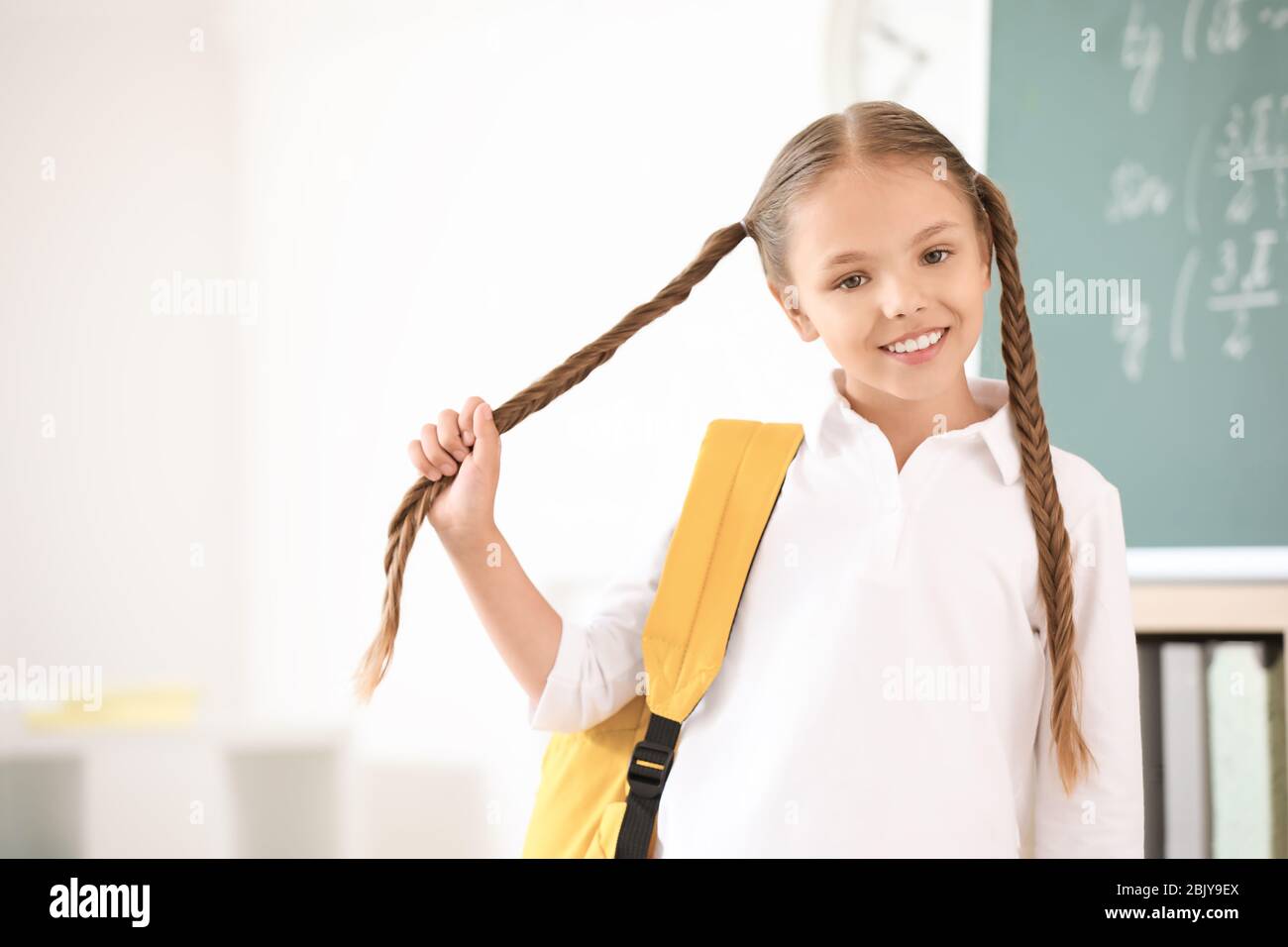 Cute little schoolgirl in classroom Stock Photo - Alamy