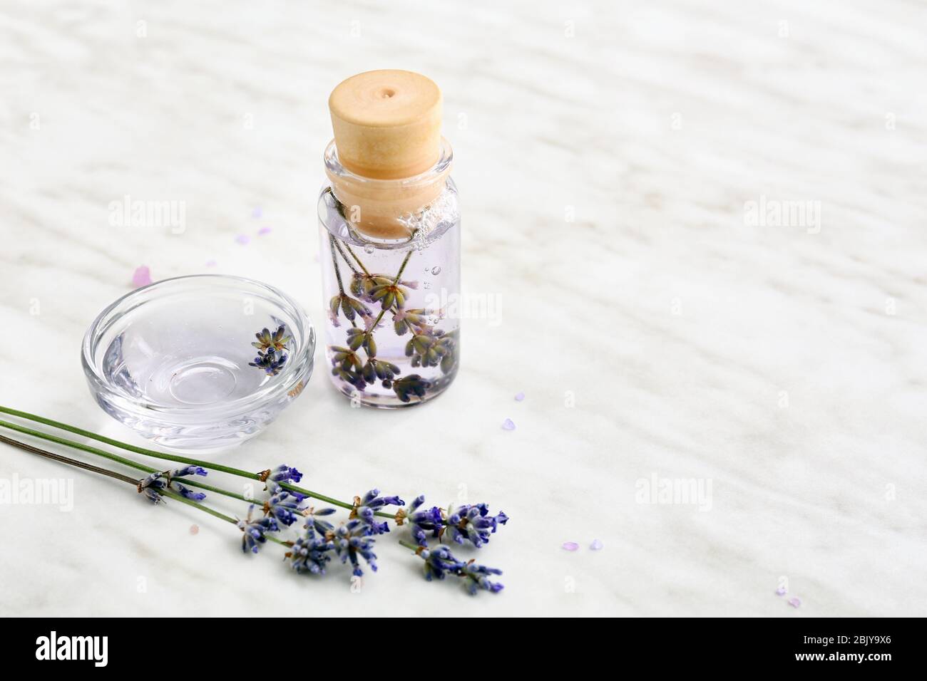 Lavender flowers with essential oil on light background Stock Photo - Alamy
