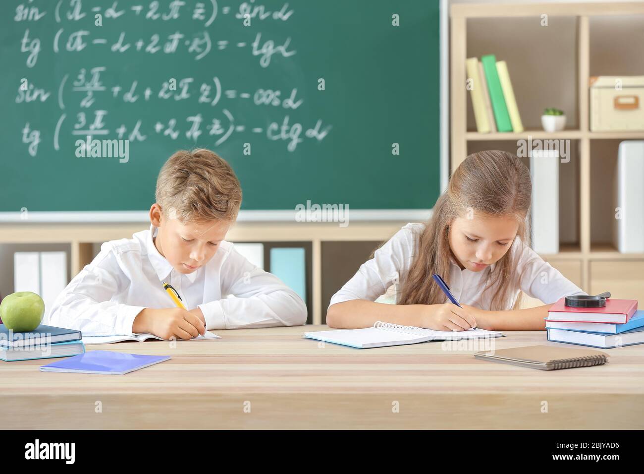 Doing Lesson Little pupils doing lessons in classroom Stock Photo - Alamy