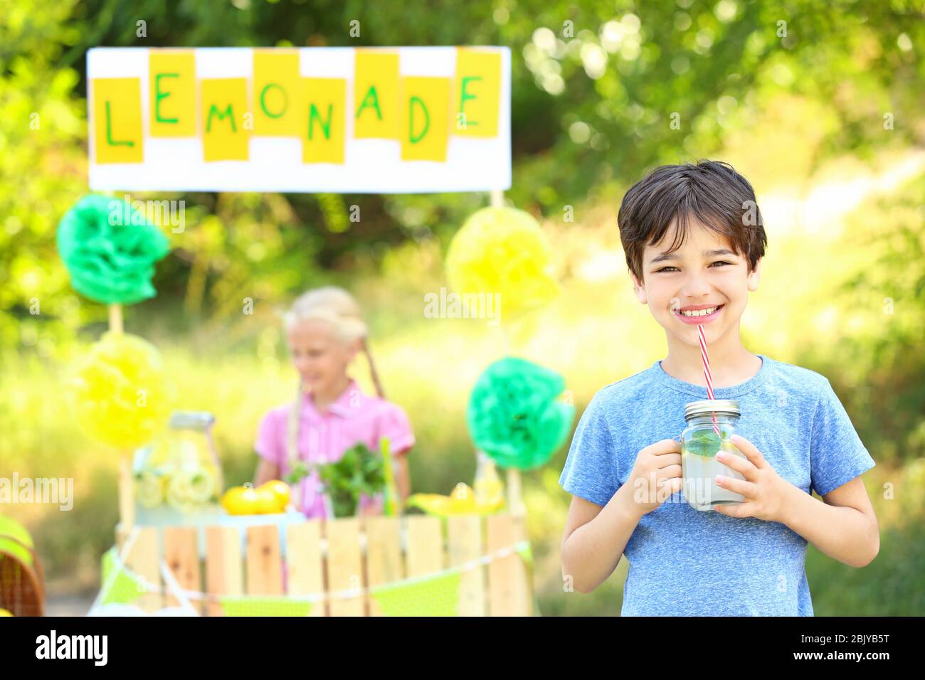 Cute little boy drinking lemonade in park Stock Photo - Alamy