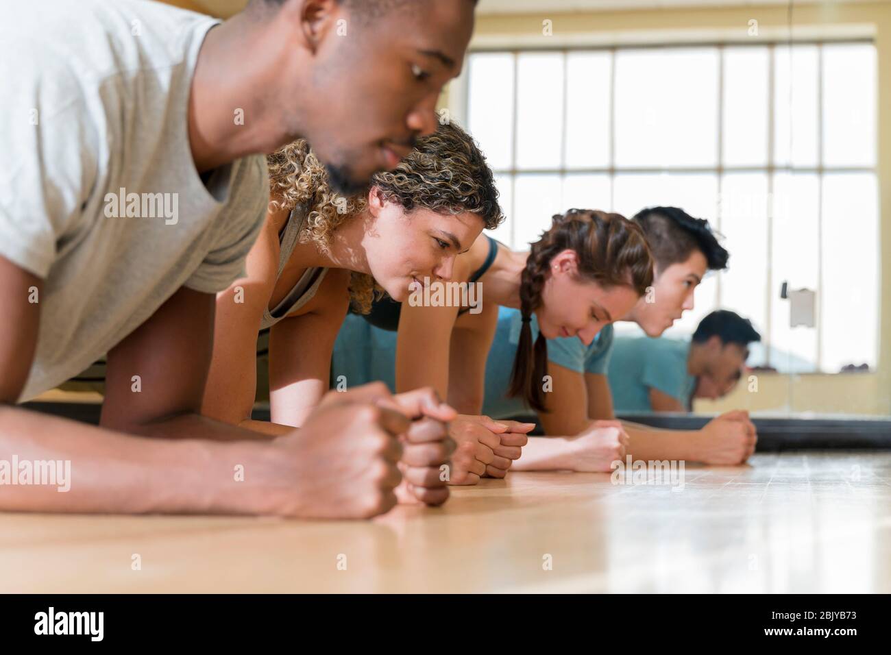 Group of friends doing planks in exercise classÂ Stock Photo