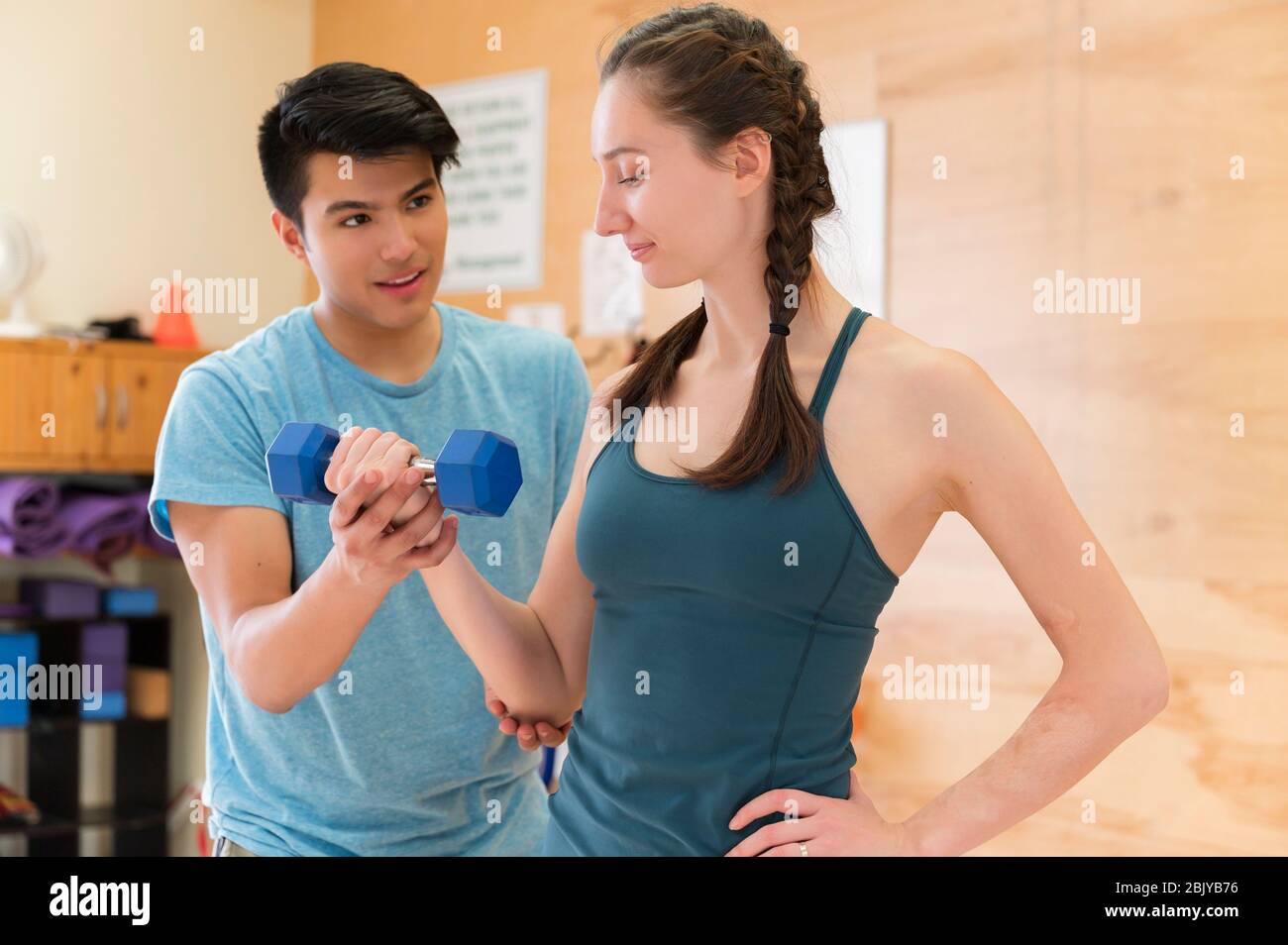 Woman workingÂ with trainer at gymÂ Stock Photo