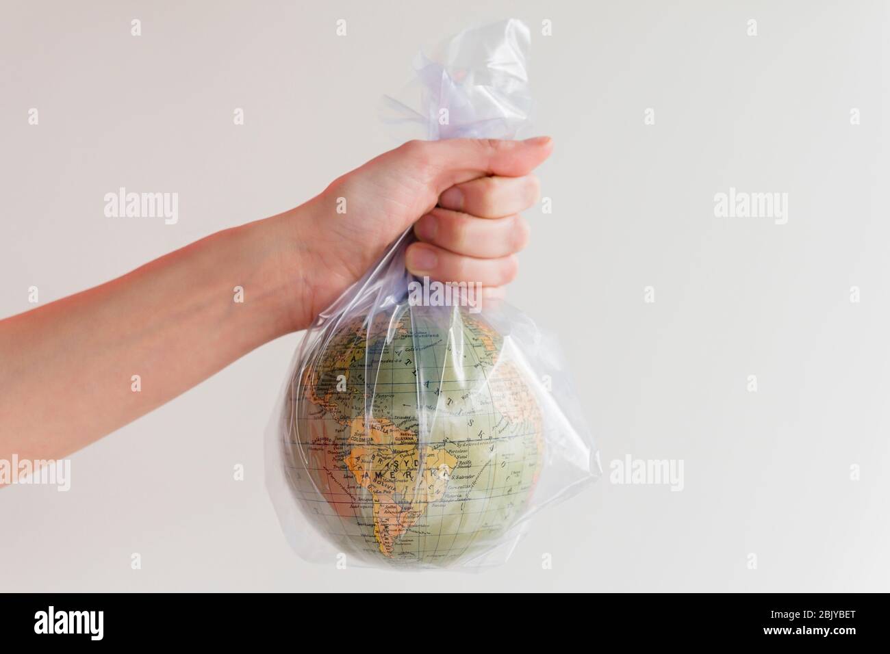 Hand holding earth globe in plastic bag Stock Photo