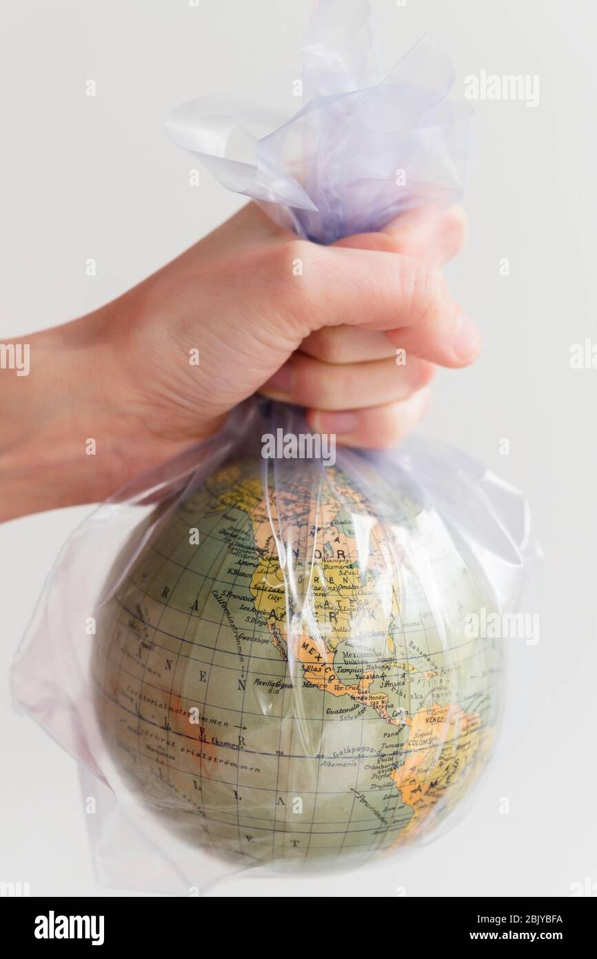 Hand holding earth globe in plastic bag Stock Photo