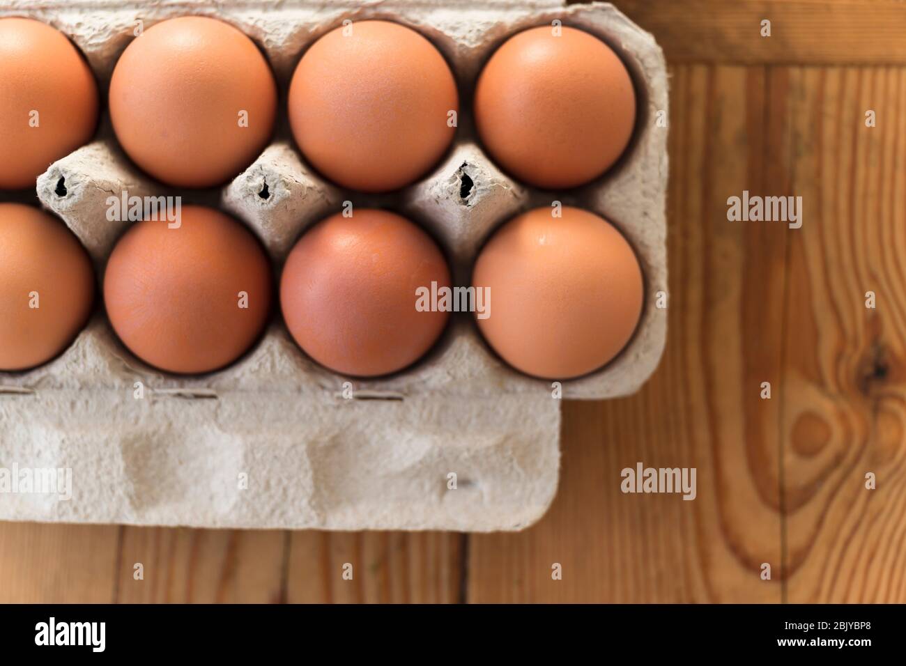 Eggs in carton on wooden tableÂ Stock Photo