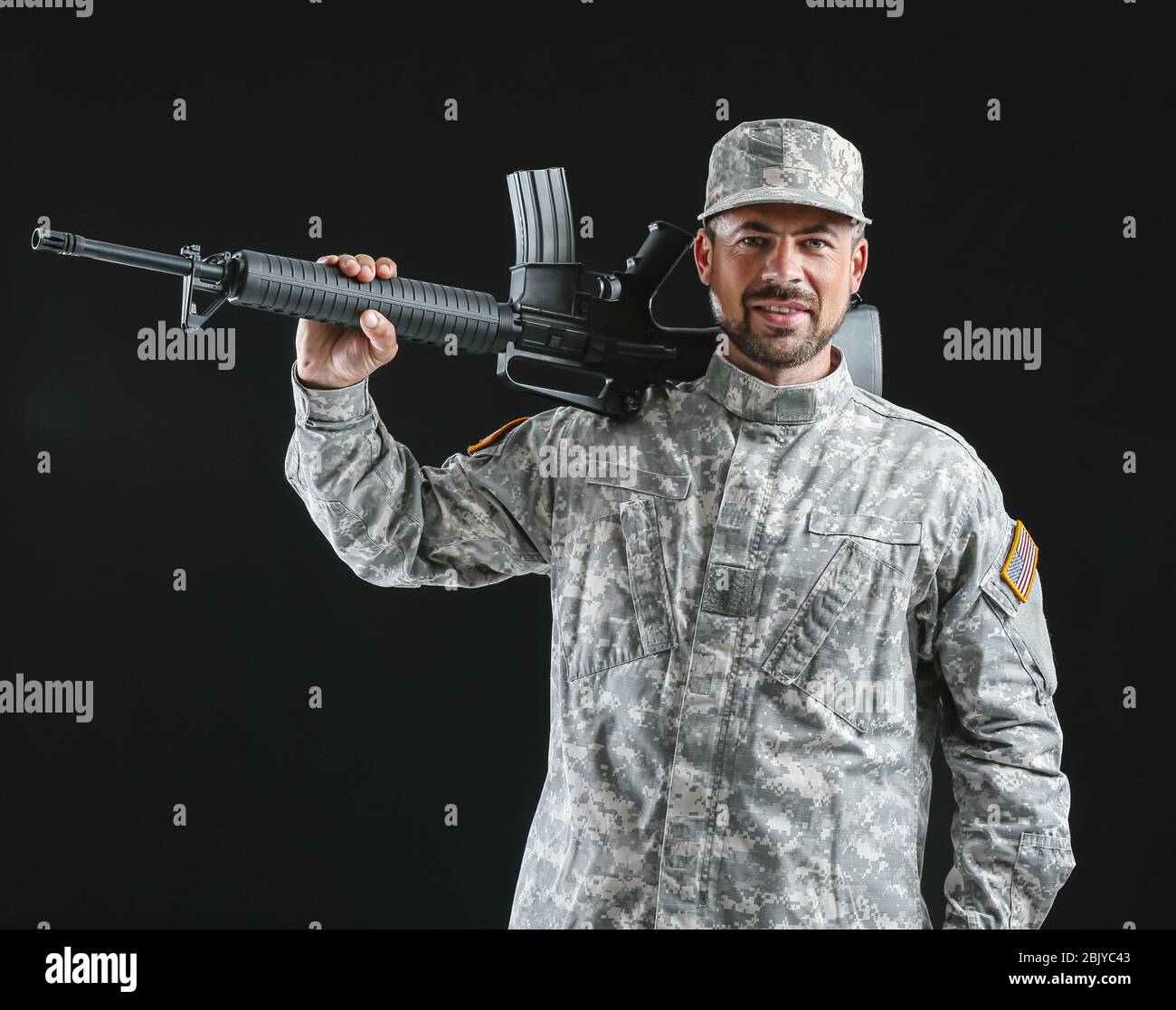 Soldier with assault rifle on dark background Stock Photo - Alamy