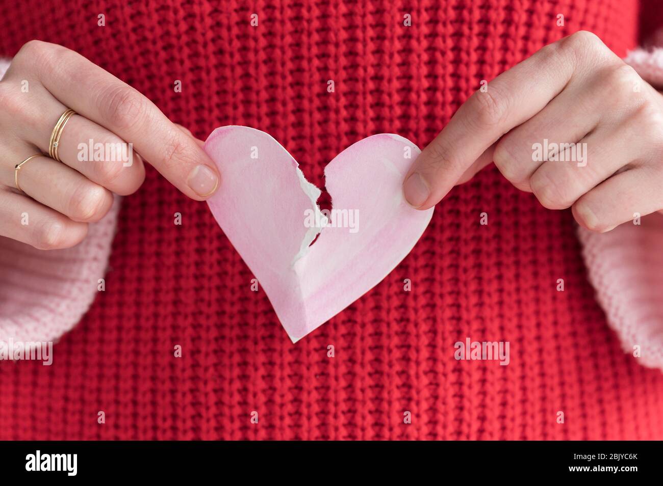 Woman ripping paper heart in half Stock Photo