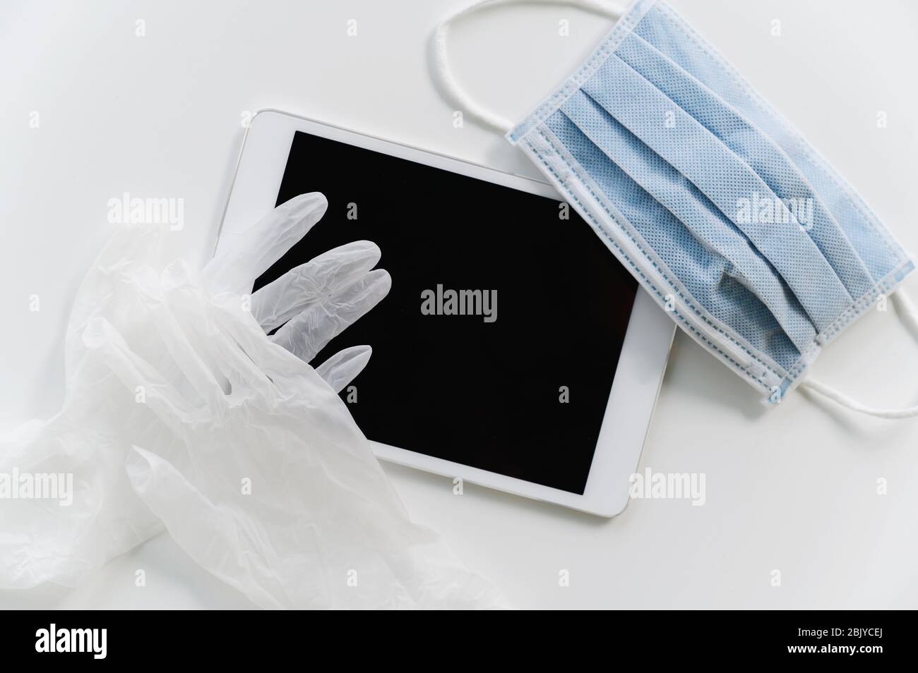 Face mask and gloves on tablet Stock Photo