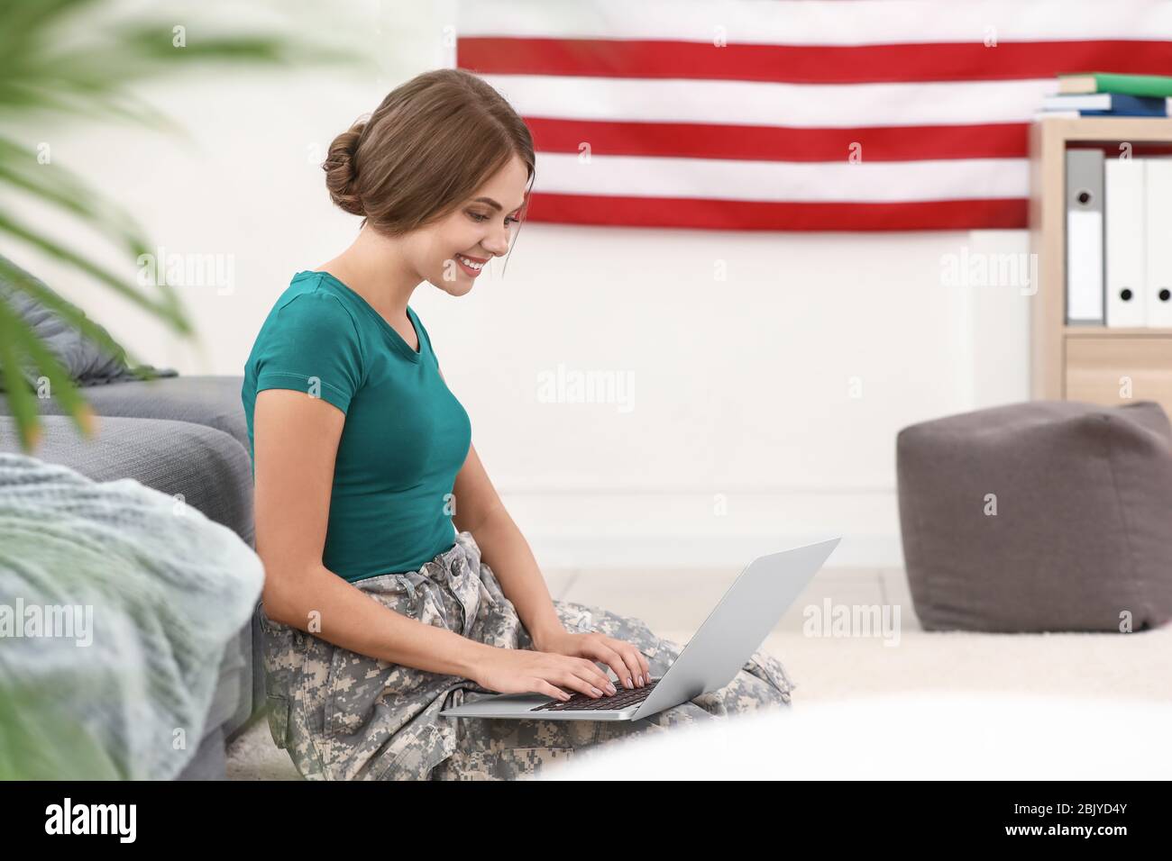 Young female soldier working with laptop in headquarters building Stock ...