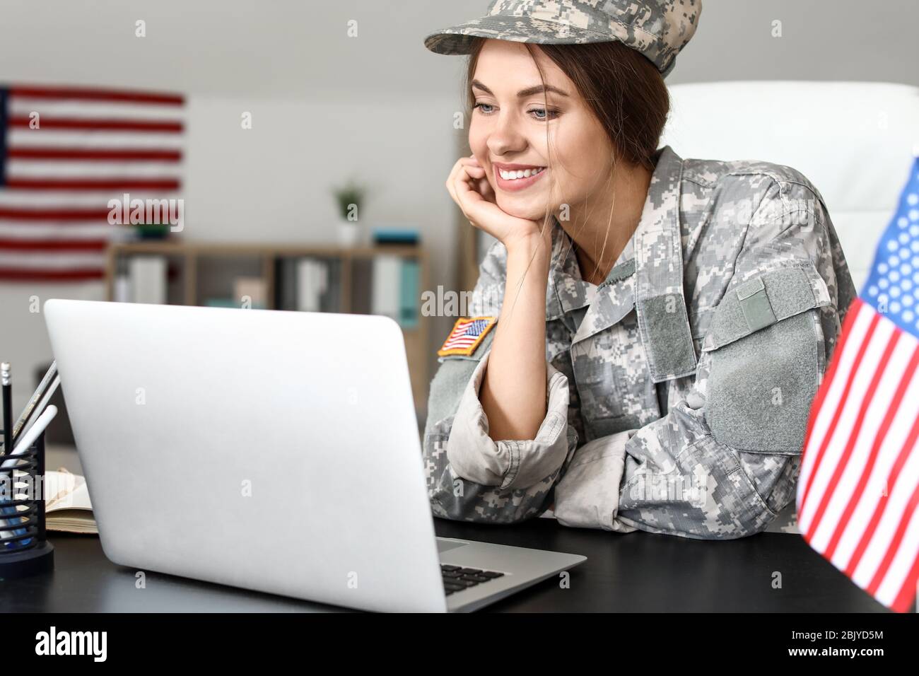 Young female soldier working with laptop in headquarters building Stock ...