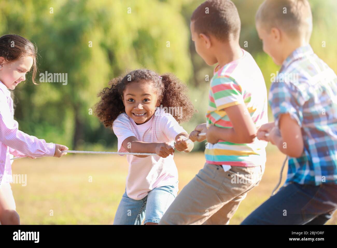Group of little children pulling rope in park Stock Photo - Alamy