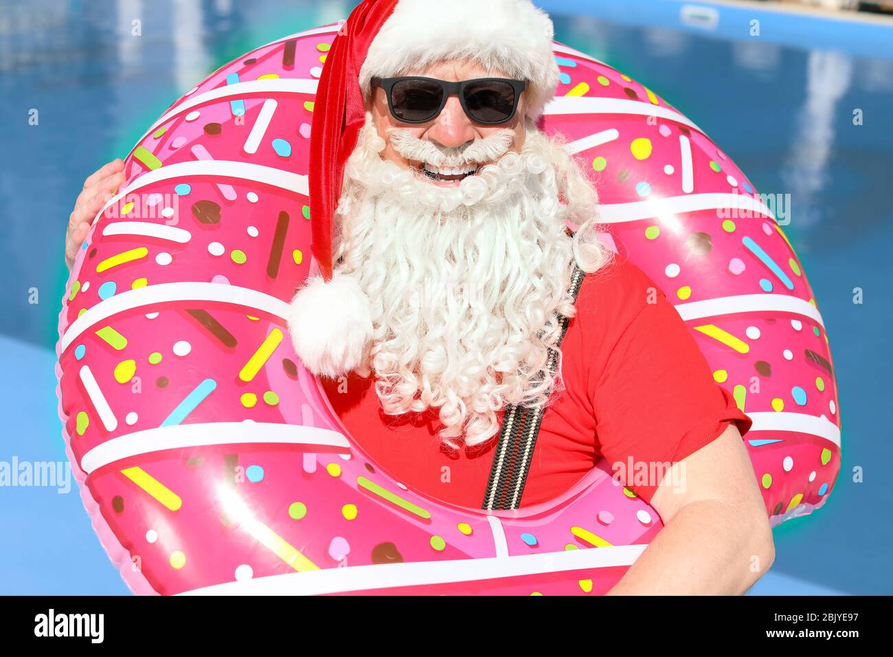 Santa Claus with inflatable ring near swimming pool at resort Stock ...