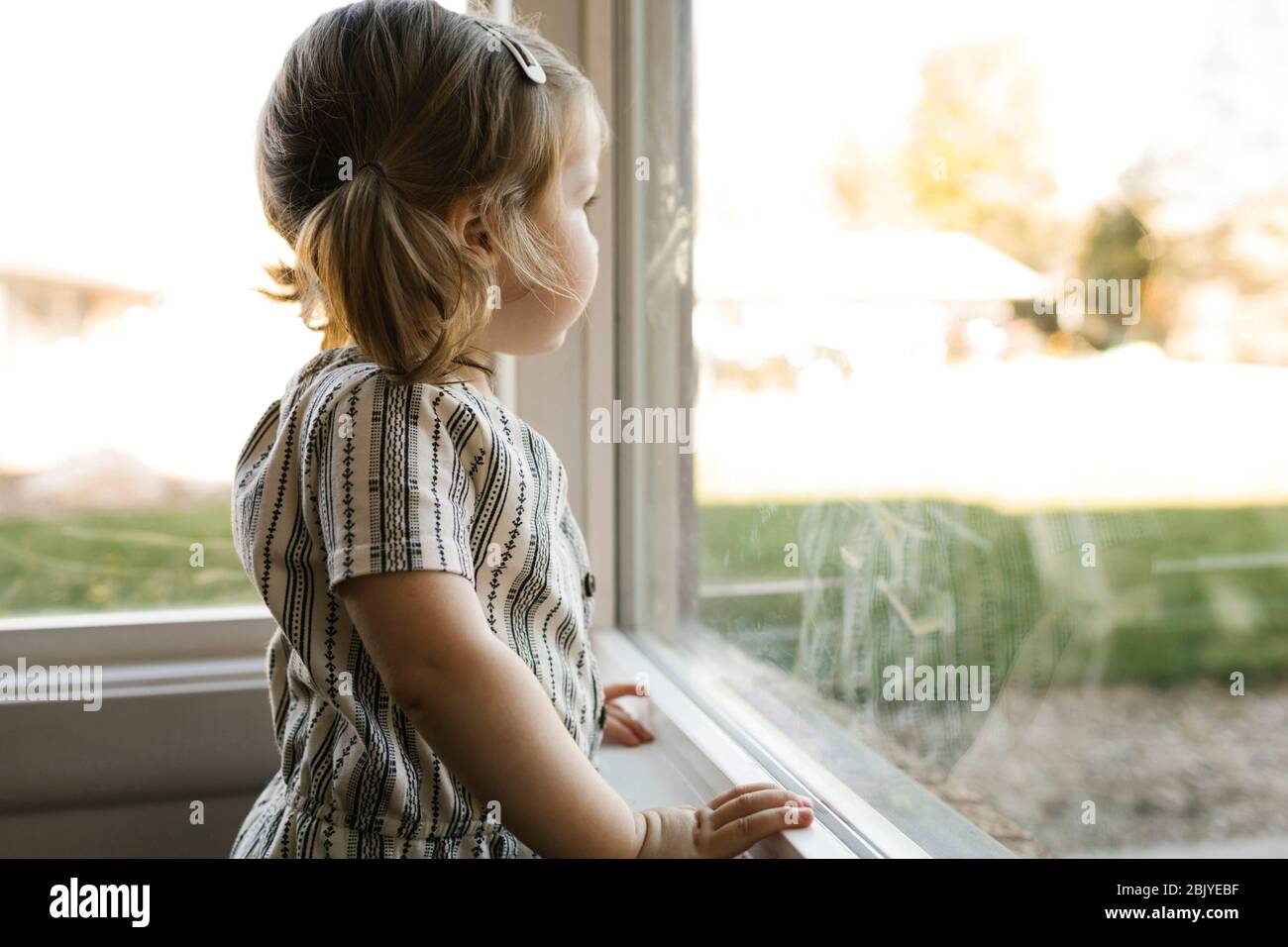 Girl (2-3) looking through window Stock Photo