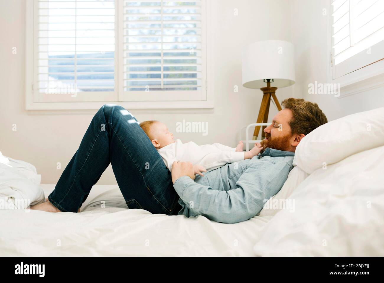 Father lying on bed with baby boy (2-3 months Stock Photo - Alamy