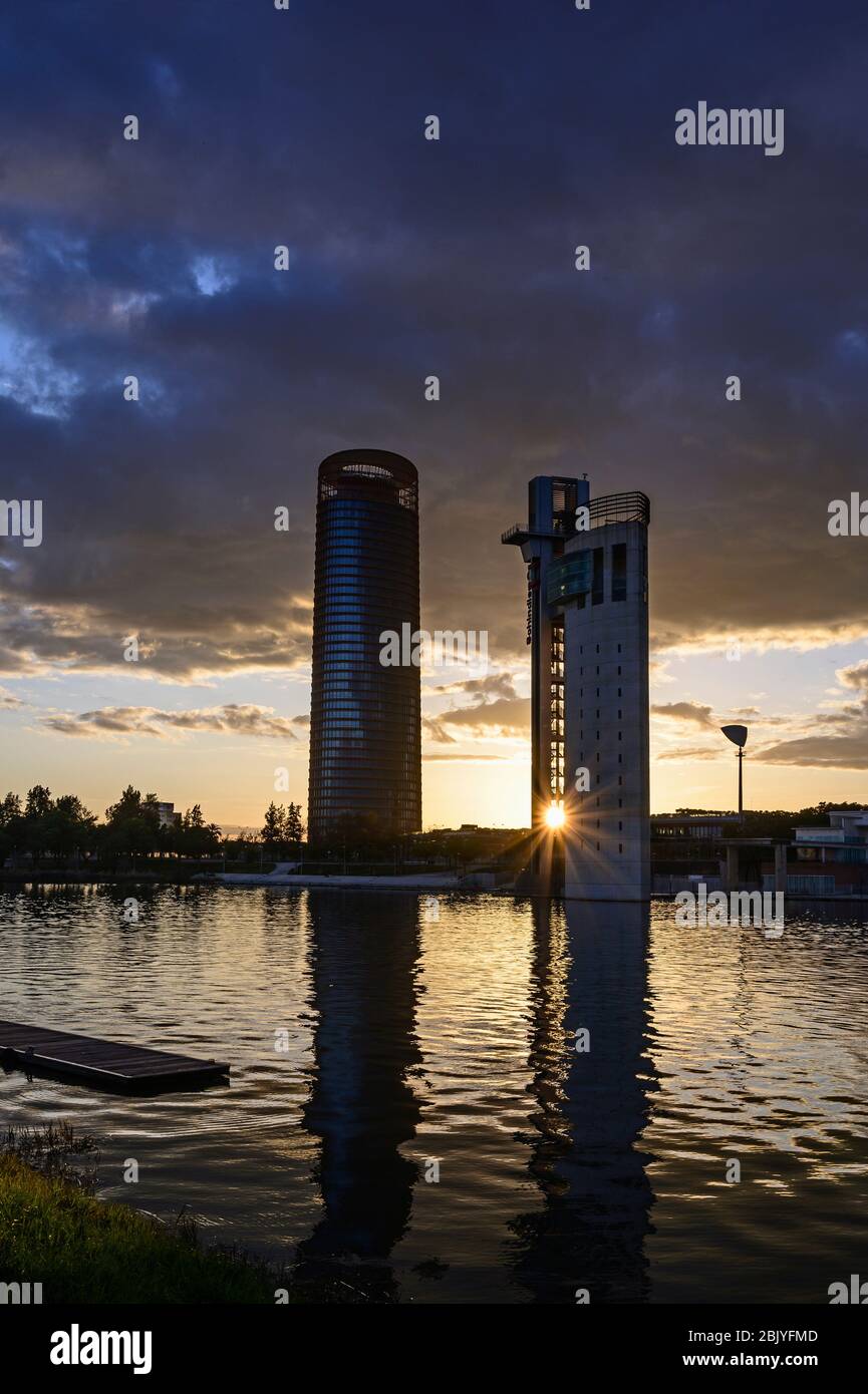 Spain, Seville, Guadalquivir River, Office blocks andÂ GuadalquivirÂ RiverÂ at sunset Stock Photo