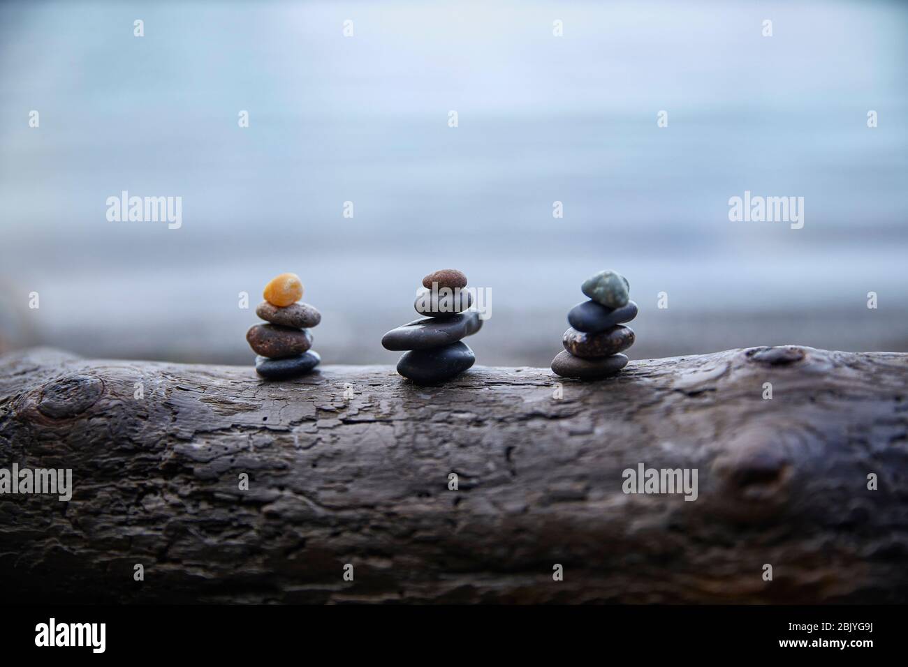USA, Washington, San Juan County, Orcas Island, Stacks of pebbles on log Stock Photo