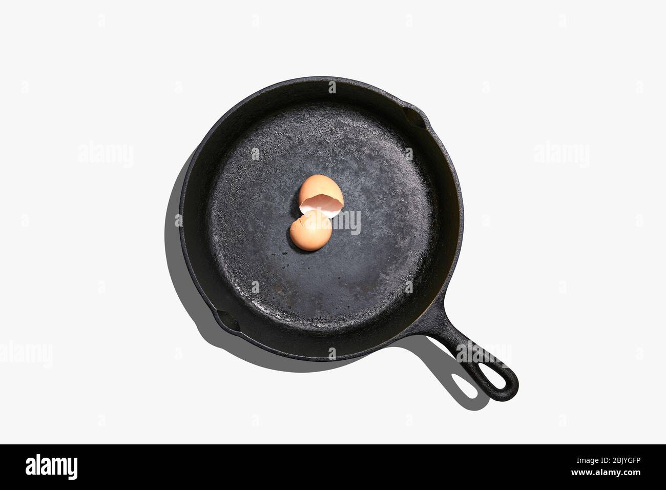Overhead view of egg shells on frying pan on white background Stock Photo