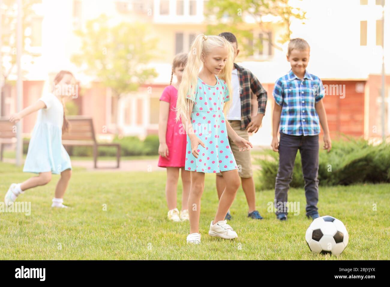 Cute little children playing football in park Stock Photo - Alamy