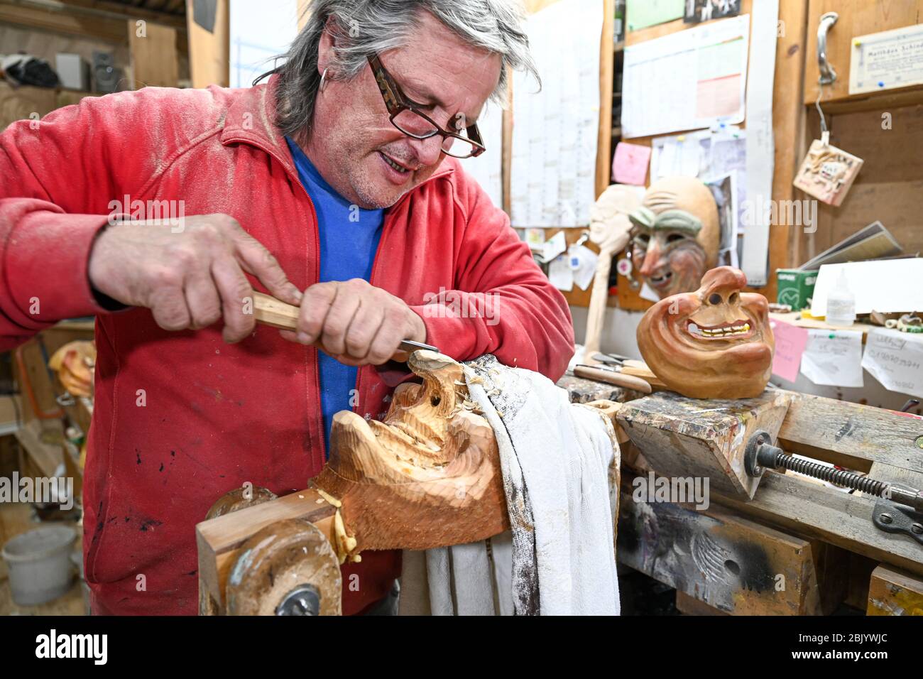 Ravensburg, Germany. 29th Apr, 2020. Mask carver Jogi Weiß carves a mask  from wood in his workshop. So that the smile is not hidden behind a  mouthguard during the Corona crisis, Jogi