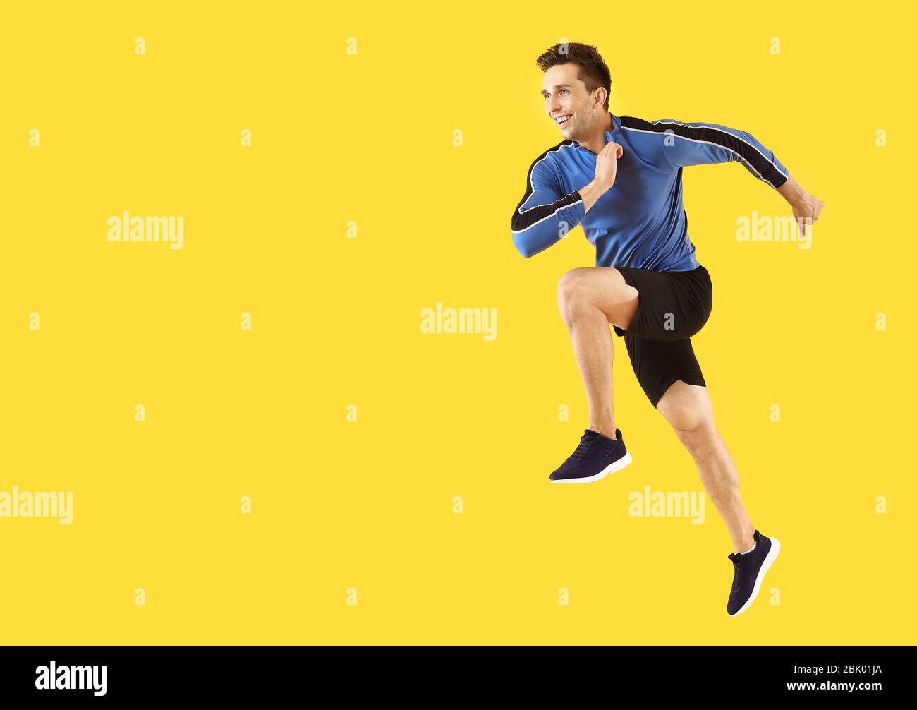 Running sporty man on color background Stock Photo - Alamy