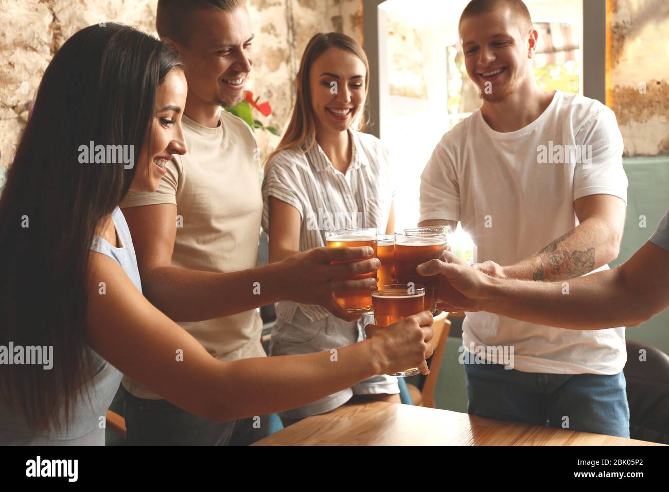 Friends drinking fresh beer in pub Stock Photo