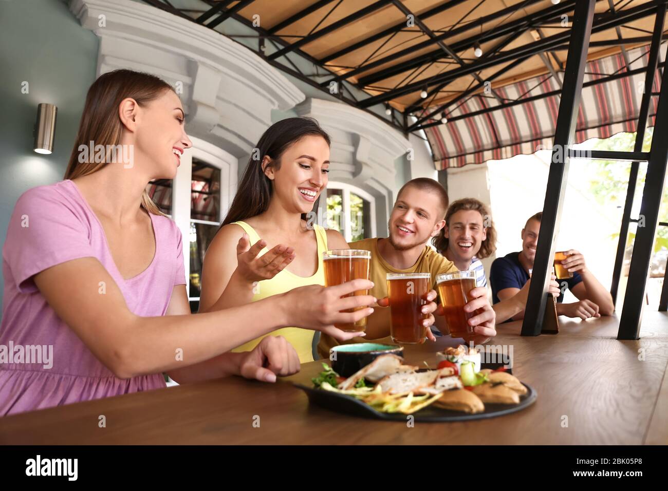 Friends drinking fresh beer in pub Stock Photo