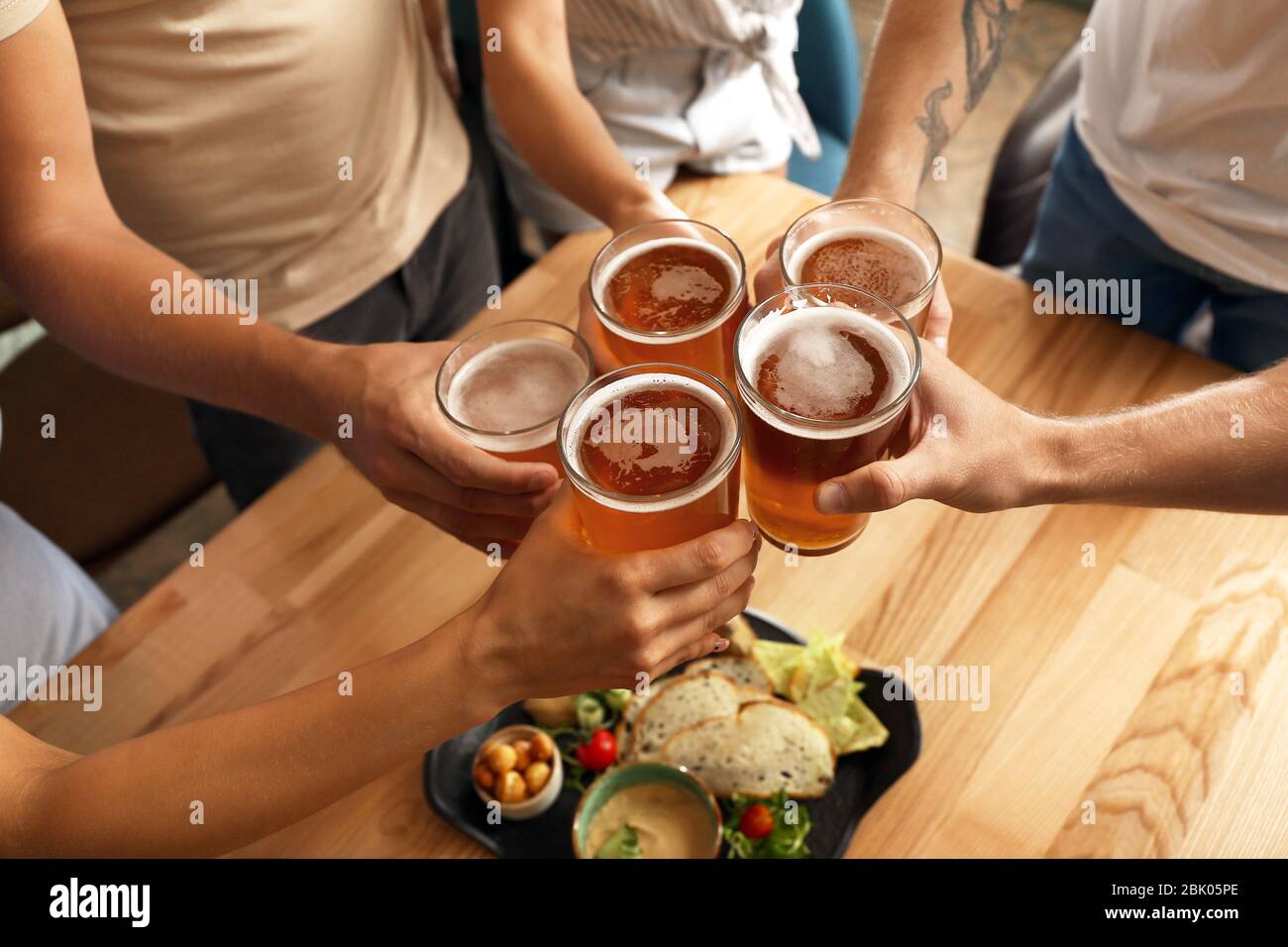 Friends drinking fresh beer in pub Stock Photo