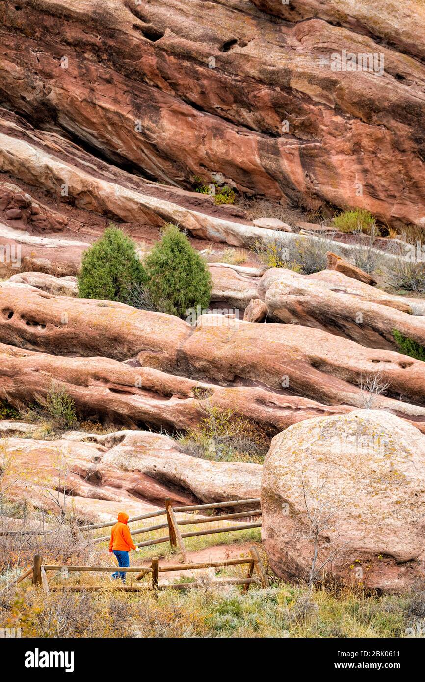 A person walks a dog near the Red Rocks Amphitheatre just outside of Denver, Colorado, USA. Stock Photo