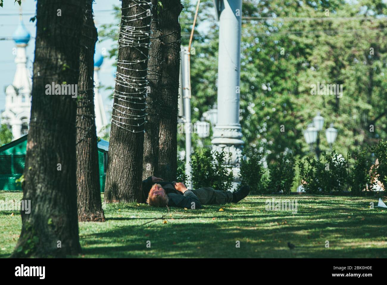 Moscow, Russia - may 31, 2014: A Homeless man sleeping on the grass lawn in the Moscow city Stock Photo