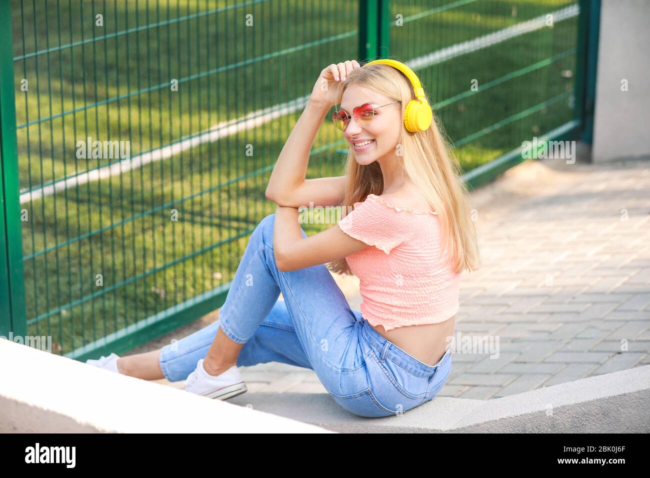 Beautiful young woman listening to music outdoors Stock Photo - Alamy