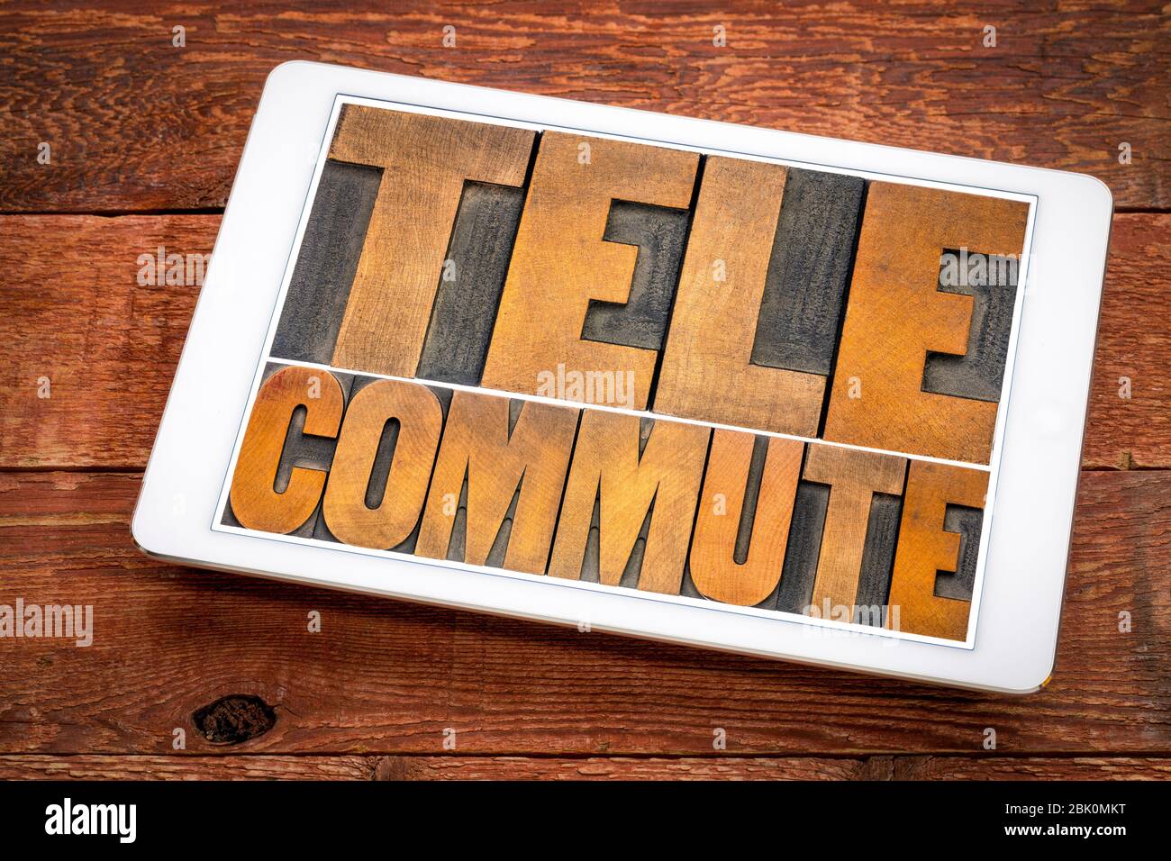 telecommute word abstract in vintage letterpress wood type on a digital tablet,  telecommuting, telework, teleworking, working from home (WFH), mobile Stock Photo