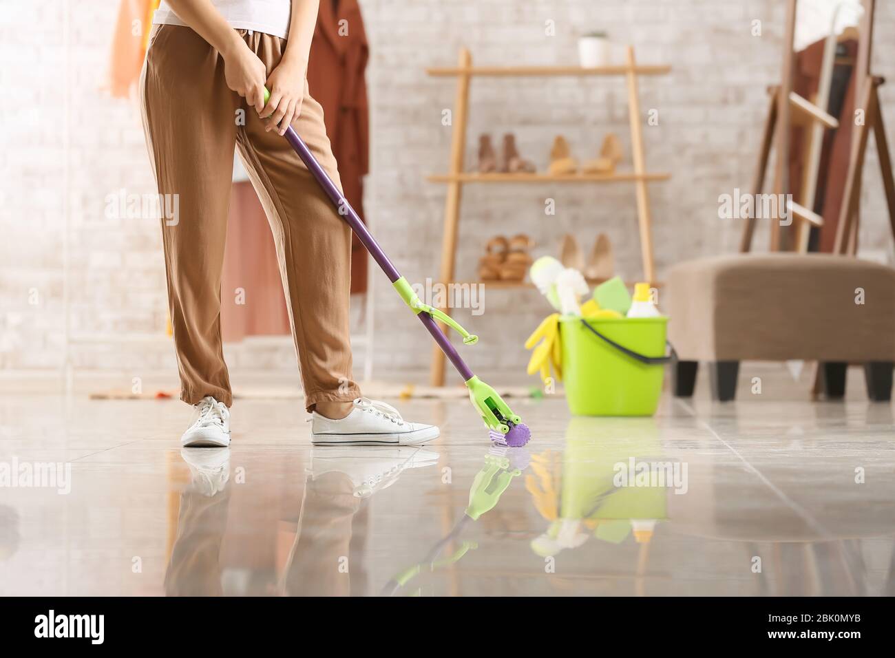 Woman mopping floor in room Stock Photo