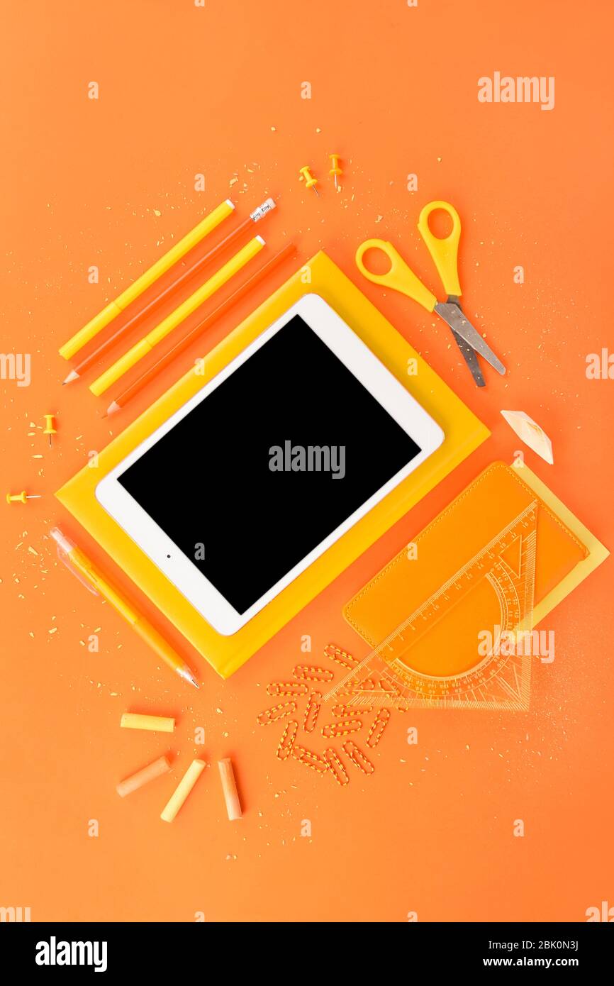 Modern tablet computer and stationery on color background Stock Photo
