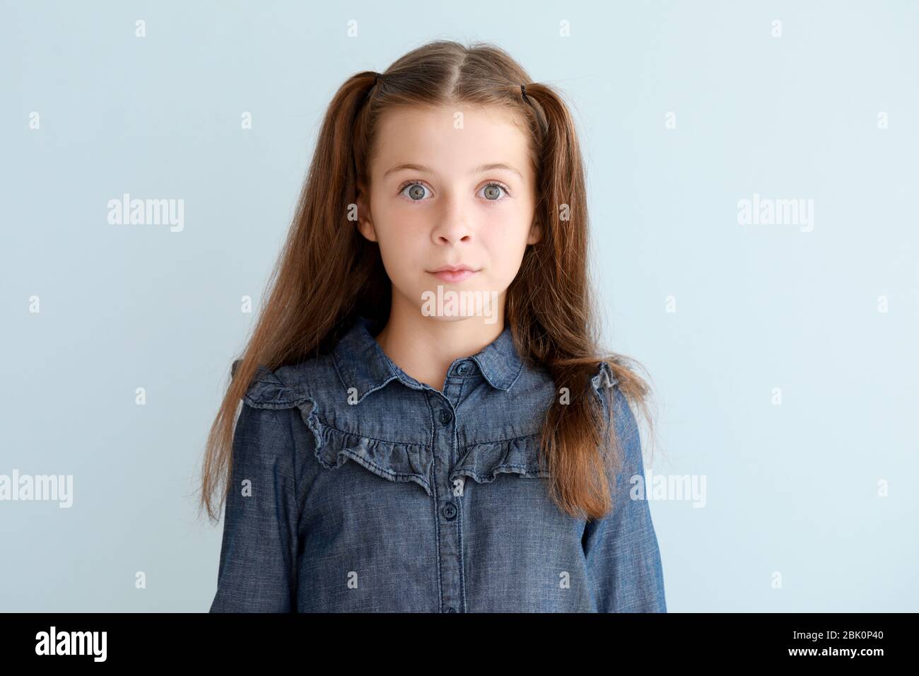 Surprised little girl on light background Stock Photo - Alamy
