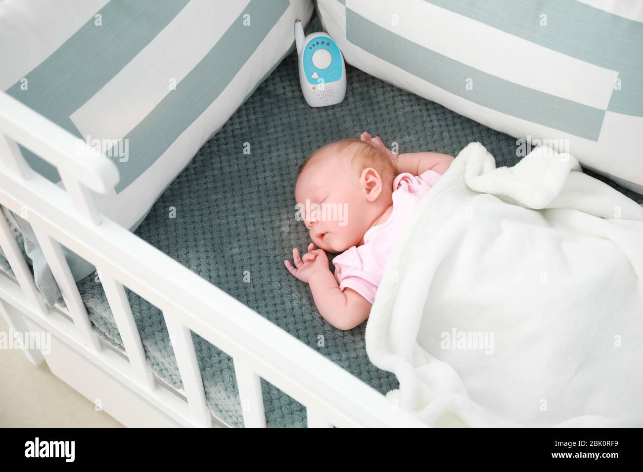 Cute little baby with radio nanny sleeping in crib Stock Photo - Alamy